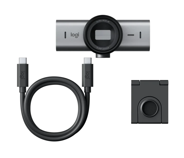 Logi webcam with accompanying USB-C cable and mounting clip laid out against black background, showing the lens, connection cable, and mount portion.