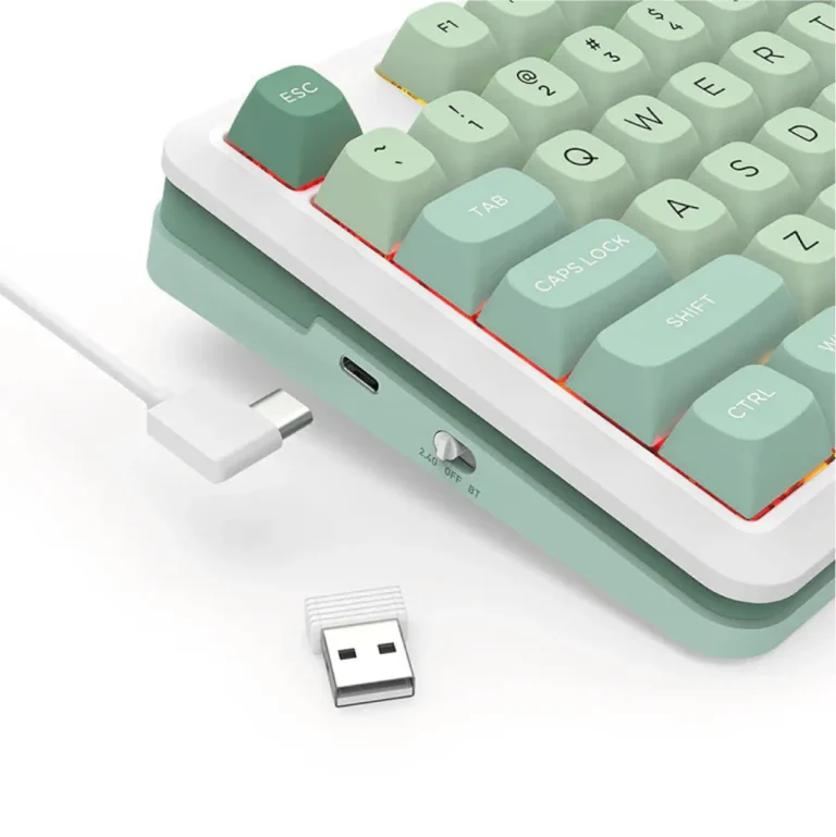 Close-up of a pastel green mechanical keyboard with a white frame, showing a USB wireless dongle and a small USB receiver on a white surface.