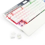 Close-up of a white mechanical keyboard with colorful RGB keycaps and several keys removed, exposing the switches beneath.