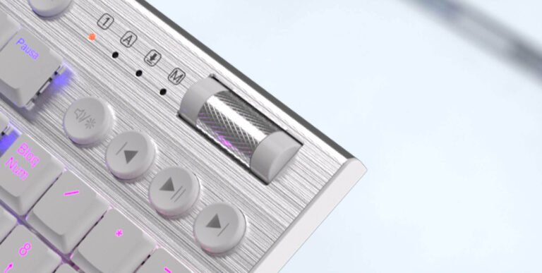 Close-up of a metallic keyboard with a textured roller control and pink backlit keys.